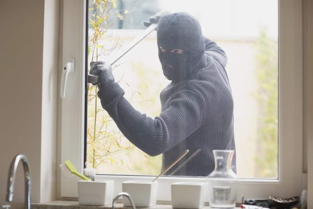 Burglar Breaking Into Home Through Window - Home Burglary Criminal Defense