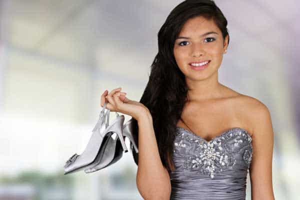 Woman in silver dress holding shoes - San Antonio quinceanera