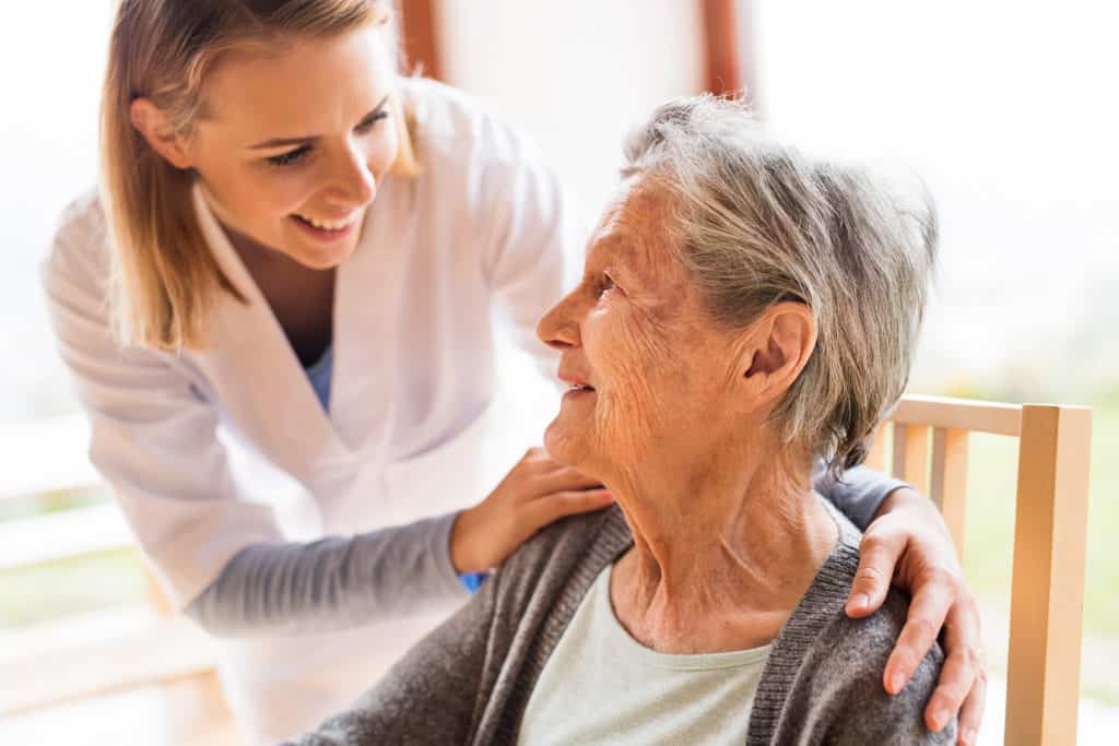 image of elderly woman receiving assisted living from nurse.