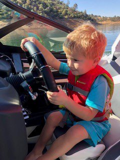 child driving boat