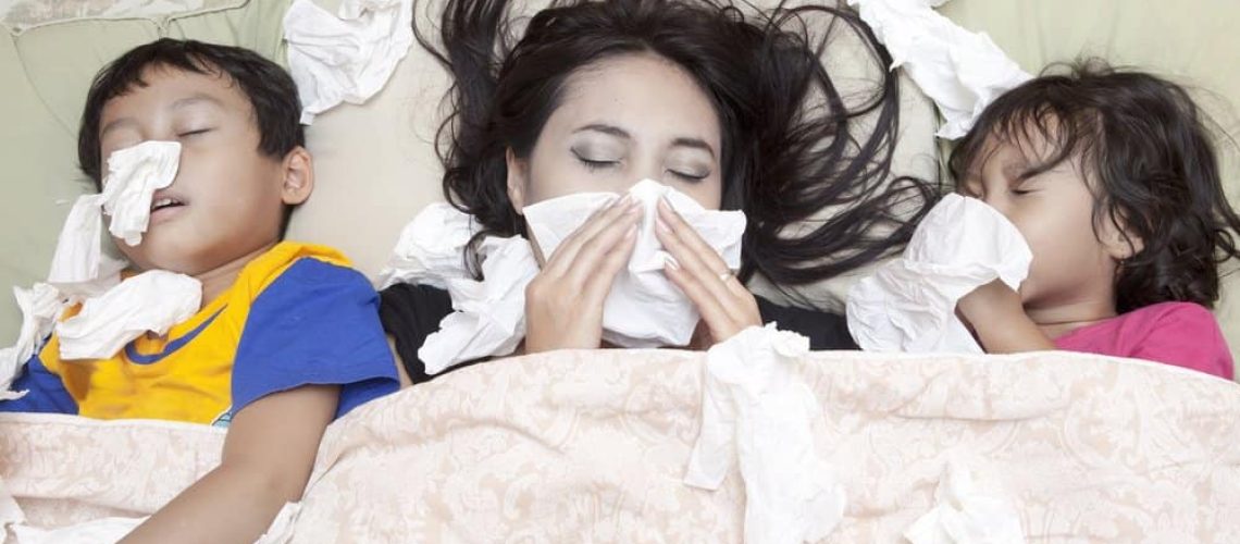 Family is lying on a bed due to flu in winter