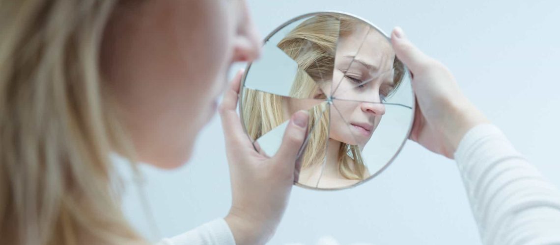 woman-looking-at-broken-mirror